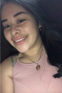 Smiling woman in a pink top.
